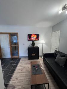 a living room with a couch and a tv on the wall at Modern Apartment good distance from Dublin City and Airport 4people in Dublin