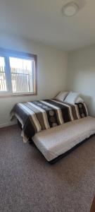 a bed in a bedroom with a large window at Suites Oriente in Osorno