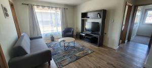 a living room with a couch and a television at Suites Oriente in Osorno
