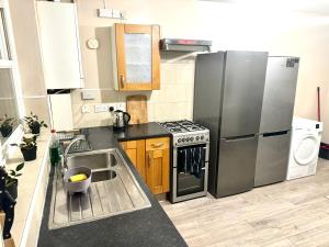 a kitchen with a stainless steel refrigerator and a sink at Central London Private Bedrooms in Finsbury Park Station in London +25 photos