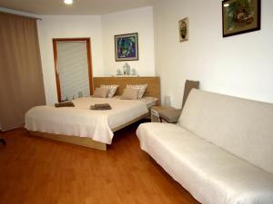 a hotel room with two beds and a couch at Apartament VISOTA in Ptuj