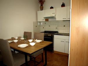 a kitchen with a wooden table with plates and bowls on it at Apartament VISOTA in Ptuj