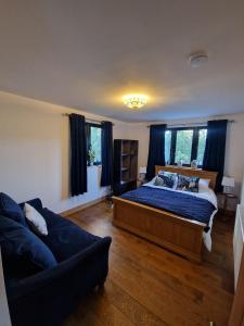a bedroom with a bed and a couch at Cedar Lodge in Bowness-on-Windermere