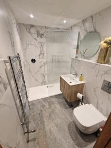 a bathroom with a shower and a toilet and a sink at Cedar Lodge in Bowness-on-Windermere +16 photos