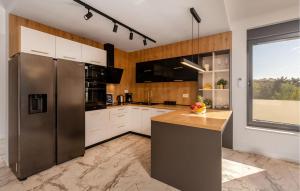 a kitchen with white cabinets and a stainless steel refrigerator at Gorgeous Home In Banjol in Banjol