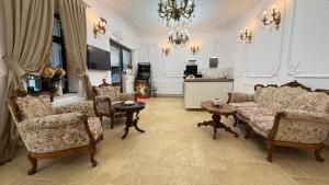 a living room with a couch and chairs and a chandelier at La Bulevard in Piteşti