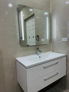 a bathroom with a white sink and a mirror at Eagle Stays Aruba-NEW Luxurious One Bedroom Apartment Near Eagle Beach! in Oranjestad +46 photos