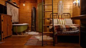 a bedroom with a bunk bed and a bath tub at Explorers Dream - Transylvania in Vlădeşti