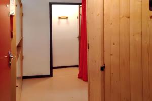 un couloir avec une porte et un rideau rouge dans l'établissement Studio cosy avec vue sur la montagne - Les Belleville - 20 m², aux Menuires