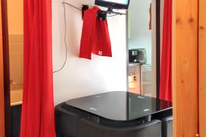 une salle de bain avec un miroir et des rideaux rouges dans l'établissement Studio cosy avec vue sur la montagne - Les Belleville - 20 m², aux Menuires