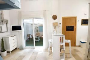 a white living room with a door and a table at Charming Apartment Málaga 40 m² + Internet in Málaga
