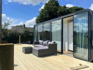 莫纳汉Pringle Pod的木甲板上配有沙发的玻璃房子
