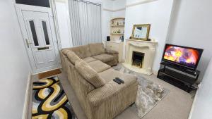 a living room with a couch and a television at Spacious-City-Late Self Checkin in Leicester