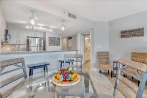 a dining room and kitchen with a glass table with a bowl of fruit at Oceanfront Work From Here Central Location! 1157 in Myrtle Beach