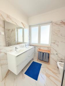 a bathroom with a white sink and a blue rug at Happy Sintra Inn Guesthouse & Breakfast in Sintra +91 photos