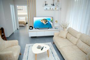 a living room with a couch and a tv at Dream house Enia 1 in Shkodër