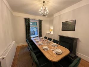 a dining room with a long table and a chandelier at Prospect House in Settle