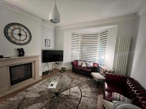 a living room with a fireplace and a clock on the wall at Prospect House in Settle