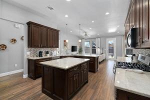 a large kitchen with wooden cabinets and a counter top at LUXE Boho Chic5BR Woodbine Round Rock Kalahari in Round Rock