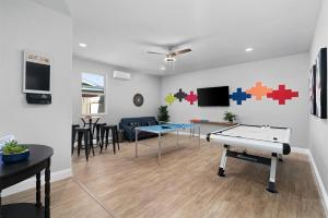 a living room with a ping pong table andidents on the wall at LUXE Boho Chic5BR Woodbine Round Rock Kalahari in Round Rock