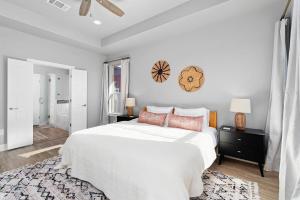 a white bedroom with a large white bed with pillows at LUXE Boho Chic5BR Woodbine Round Rock Kalahari in Round Rock