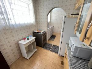 a small kitchen with a stove and a refrigerator at Casa aconchegante para família- 3,5 km do centro histórico in Petrópolis +46 photos