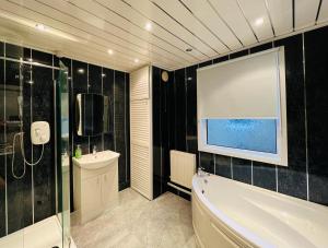 a bathroom with a bath tub and a sink at Prospect House in Settle