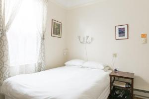 a bedroom with a white bed and a window at Green Tortoise Hostel in San Francisco +37 photos