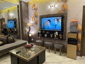 a living room with a couch and a tv on a wall at Exquisite Luxe 2 Bedroom Condo Close to GIGA MALL in Islamabad