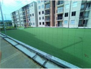 a tennis court with a net in front of a building at Lilia's House Santa Marta in Santa Marta