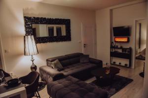 a living room with a couch and a mirror at Lux Grey in Đakovo