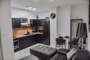 a living room with a couch and a kitchen at Lux Grey in Đakovo