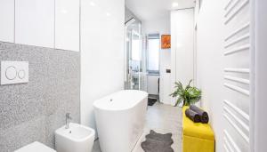 La salle de bains est pourvue d'une baignoire blanche et d'un chat. dans l'établissement The Royal Goat Near Castle and Presidential Palace, à Bratislava