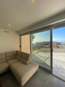 a living room with a couch and a sliding glass door at Casa Klei in Ulcinj