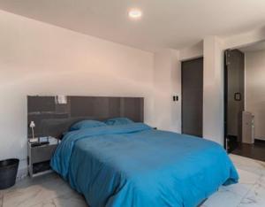 a bedroom with a large blue bed in it at Penthouse Elysium in Mexico City