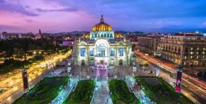 a view of a building with a dome at night at Penthouse Elysium in Mexico City