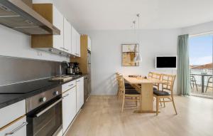 a kitchen with a table and a dining room at Gudhjem Søpark Lejl 18 in Gudhjem