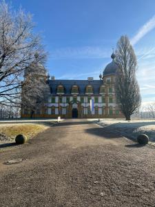 a large yellow building with a tree in front of it at Ferienwohnung Seehofblick in Memmelsdorf