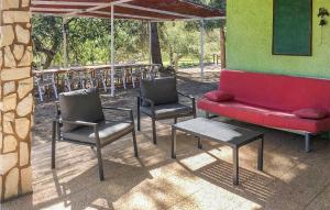 a group of chairs and a red couch and a table at Awesome Home In Ardenya With Wifi in Ardenya