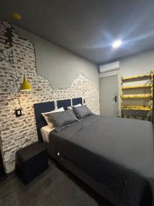 a bedroom with a bed and a brick wall at POUSADA BRAGANTINA Economic in Bragança Paulista +5 photos