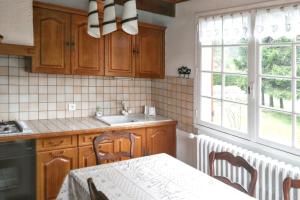 a kitchen with a table and a sink and a window at Maison charmante au cœur du Chambon-sur-Lignon avec jardin in Le Chambon-sur-Lignon