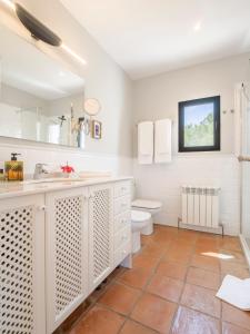 a white bathroom with a toilet and a sink at Villa Tosalet Pomelo in Jávea