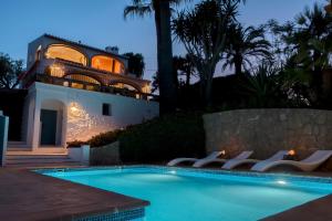 a house with a swimming pool in front of a house at Villa Tosalet Pomelo in Jávea
