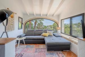 a living room with a couch and a large window at Villa Tosalet Pomelo in Jávea