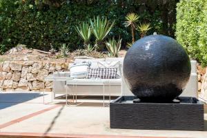 a black vase sitting next to a bench in a garden at Villa Tosalet Pomelo in Jávea