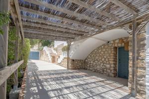 a wooden pergola on the side of a building at Villa Tosalet Pomelo in Jávea
