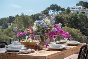 a table with plates and glasses and flowers on it at Villa Tosalet Pomelo in Jávea