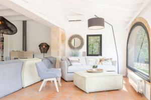 a living room with white furniture and a window at Villa Tosalet Pomelo in Jávea