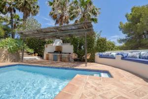 a swimming pool in a backyard with a pergola at Villa Tosalet Pomelo in Jávea