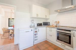 a kitchen with white cabinets and a stove top oven at Villa Tosalet Pomelo in Jávea